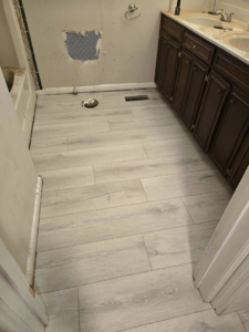 Completed installation of light hardwood flooring in a bathroom by Refined Hardwood Flooring LLC in Wilmington, NC