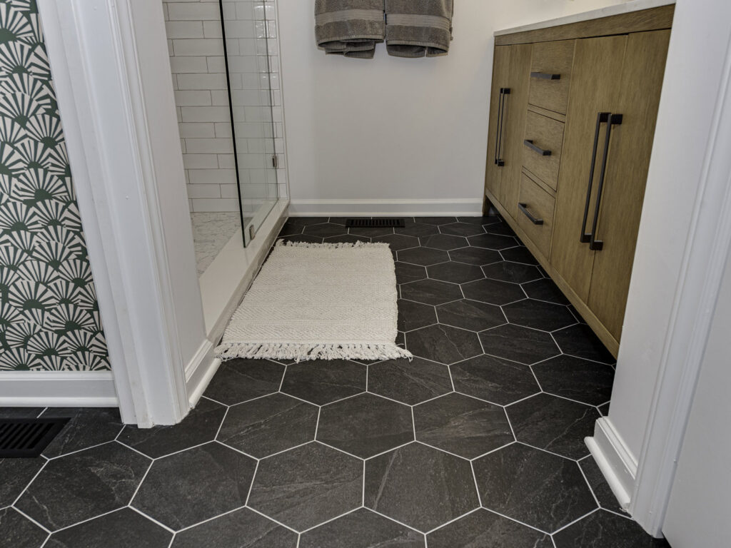 Newly installed black hexagonal floor tiles in a bathroom, a quality flooring service by Boyd's Custom Building in Charlotte, NC.