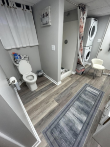 Bathroom with newly installed LVP flooring and stacked washer and dryer by Kings Handyman Services in Dallas, TX