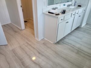 Bathroom LVP flooring installation with a white vanity by Gladiator Flooring LLC in Summerville, SC.