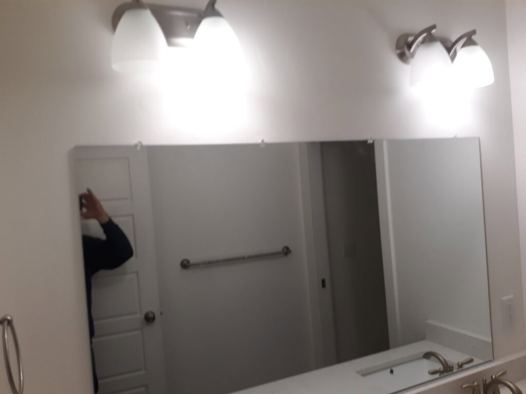 Installation of a new bathroom mirror and modern light fixtures by Eagle Rock Handyman Services in Caldwell, ID.