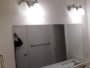 Installation of a new bathroom mirror and modern light fixtures by Eagle Rock Handyman Services in Caldwell, ID.