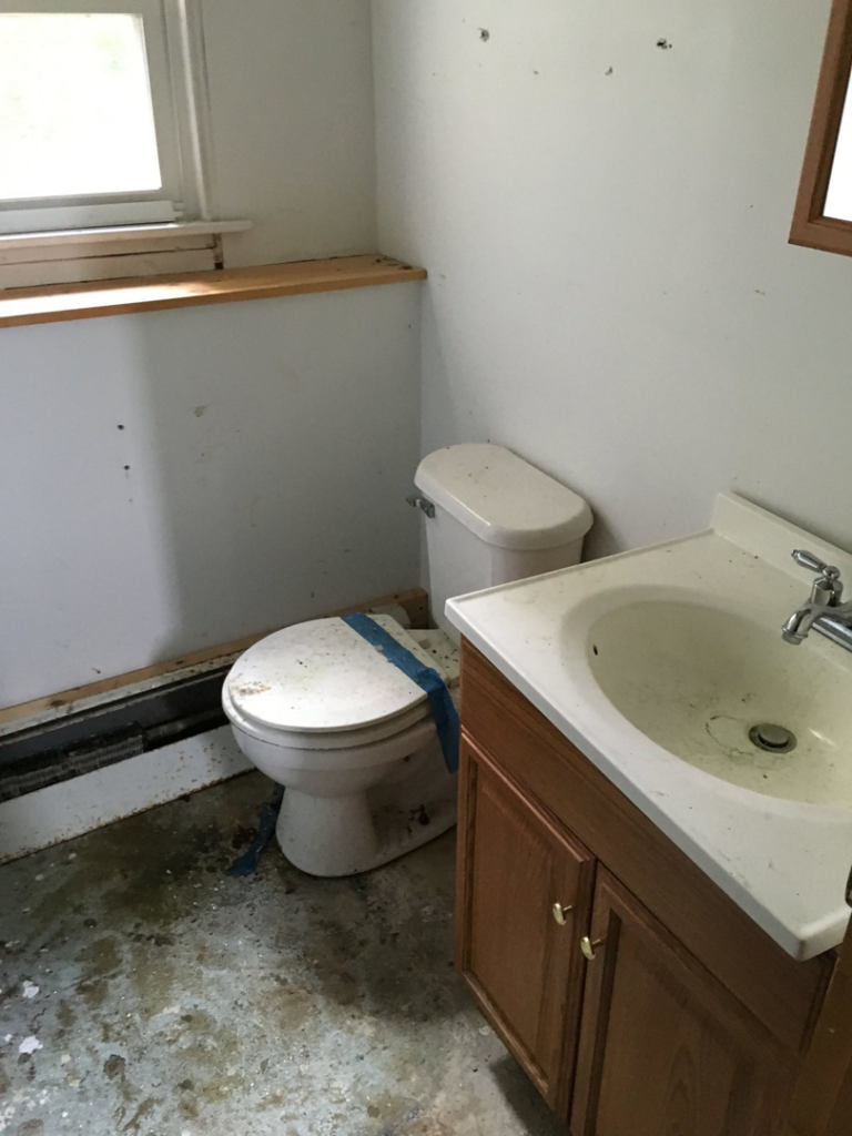 A bathroom needing renovation with an old toilet and sink, a common handyman service by Lemelin General Contracting in Fall River, MA.