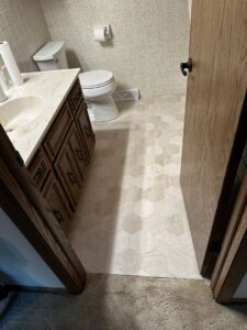 A bathroom featuring newly installed hexagonal flooring and a vanity, completed by Hawk Handyman Services in West Fargo, ND