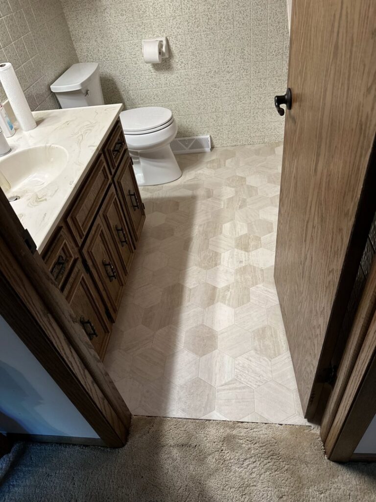 A bathroom featuring newly installed hexagonal flooring and a vanity, completed by Hawk Handyman Services in West Fargo, ND