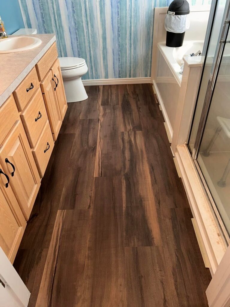 New laminate flooring installed in a bathroom by Jonny Handyman Services in Roy, UT.