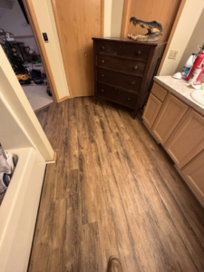 A bathroom with new laminate flooring and vanity installed by All-In-One Contracting and Home Improvement in Canton, OH