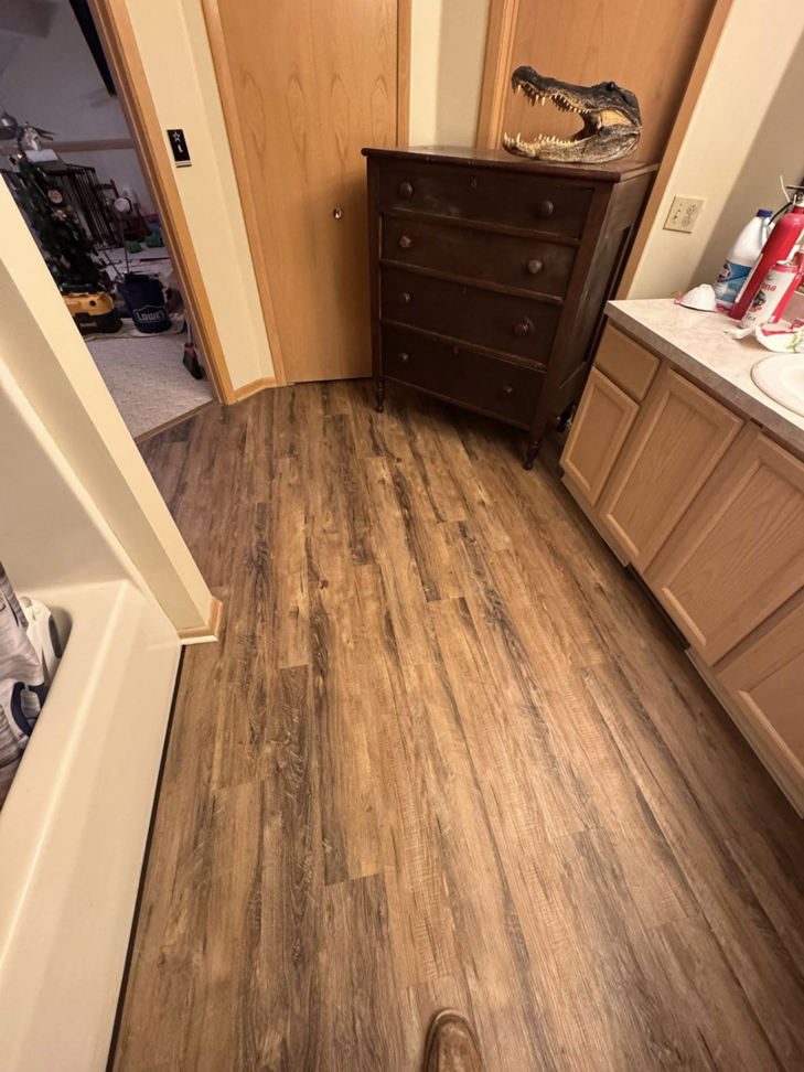 A bathroom with new laminate flooring and vanity installed by All-In-One Contracting and Home Improvement in Canton, OH