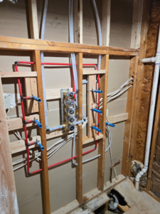 Bathroom wall framing with new PEX plumbing and electrical rough-ins by Michael South Home Renovations in Fort Worth, TX.