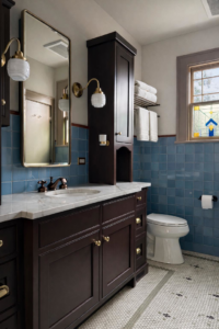 A complete bathroom remodel featuring blue tiled walls, a dark wood vanity, and new fixtures by Kyle Build in Chattanooga, TN.