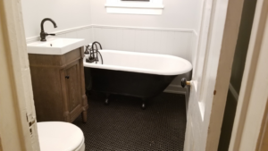 A beautifully renovated bathroom featuring a clawfoot tub and new vanity by Quality Home Improvement in Pulaski, Chicago, IL.