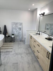 A spacious bathroom remodel with a double vanity, freestanding tub, and tiled floor by NP General Contracting in Austin, TX.