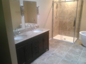 A newly renovated bathroom featuring a double vanity, walk-in shower, and freestanding tub by Paulus Contracting in Fayetteville, OH