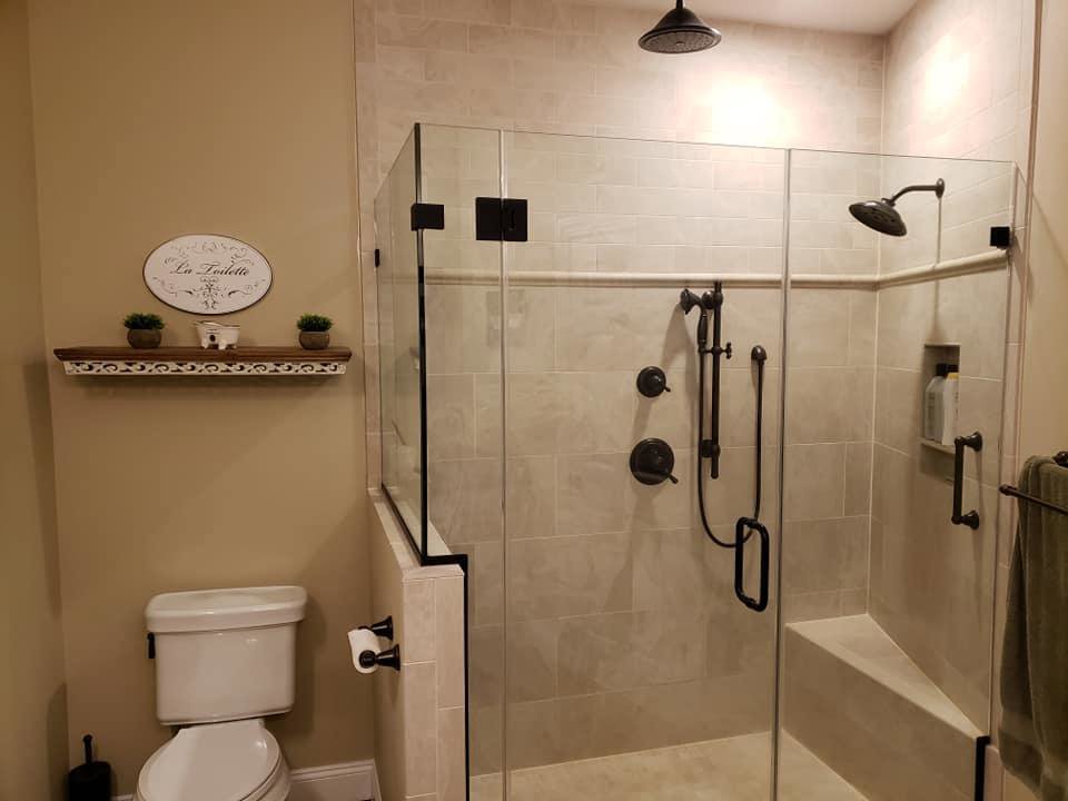 A modern bathroom remodel featuring a sleek glass shower enclosure and new fixtures by Mainville Construction & Remodeling LLC in Newington, CT.