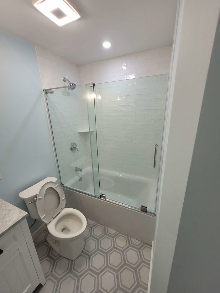 Newly remodeled bathroom with a glass shower enclosure and new vanity by Priority Property Services in Salisbury, MD.