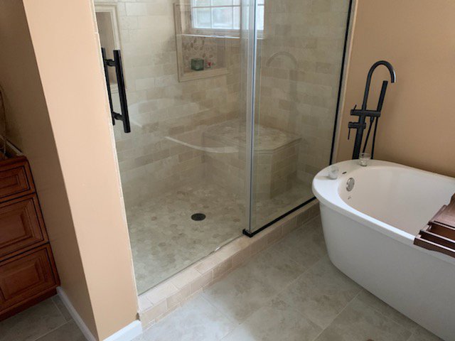 A bathroom remodel with a glass shower enclosure and freestanding tub by Indy Renovation in Indianapolis, IN.