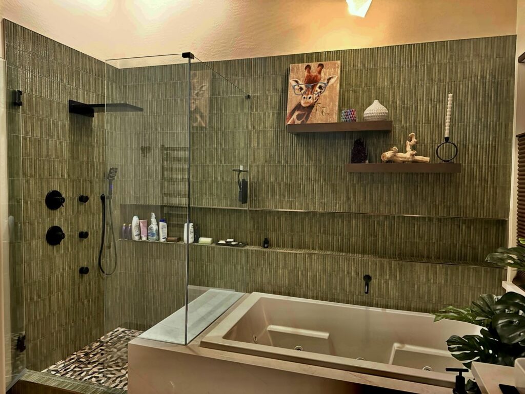 A modern bathroom remodel with dark green textured tiles, a walk-in shower, and a bathtub by Desert Remodel in Scottsdale, AZ.