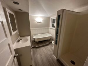 Modern bathroom remodel with new flooring, a sleek vanity, freestanding bathtub, and shower by NS Construction in Imperial, CA.