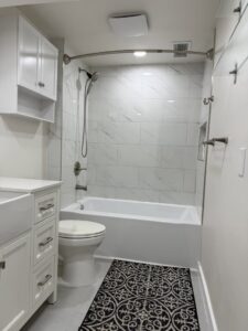 A newly remodeled bathroom with a white tiled shower and tub combination by JP. Remodel Service LLC in Everett, WA.
