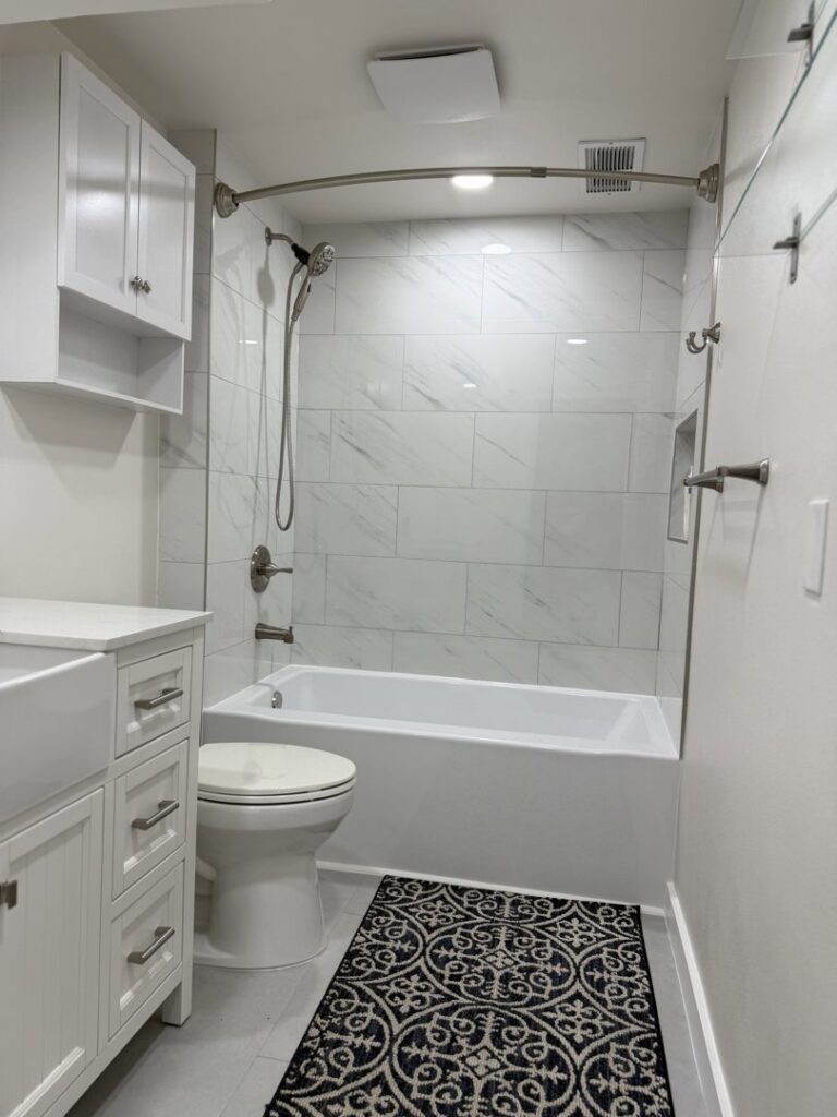 A newly remodeled bathroom with a white tiled shower and tub combination by JP. Remodel Service LLC in Everett, WA.