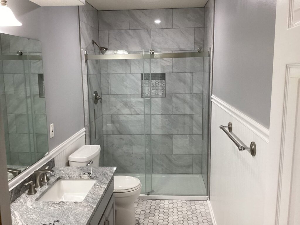 A newly remodeled bathroom featuring a modern tiled shower and new vanity by Mr. Handyman of Olathe, Gardner in Olathe, KS.