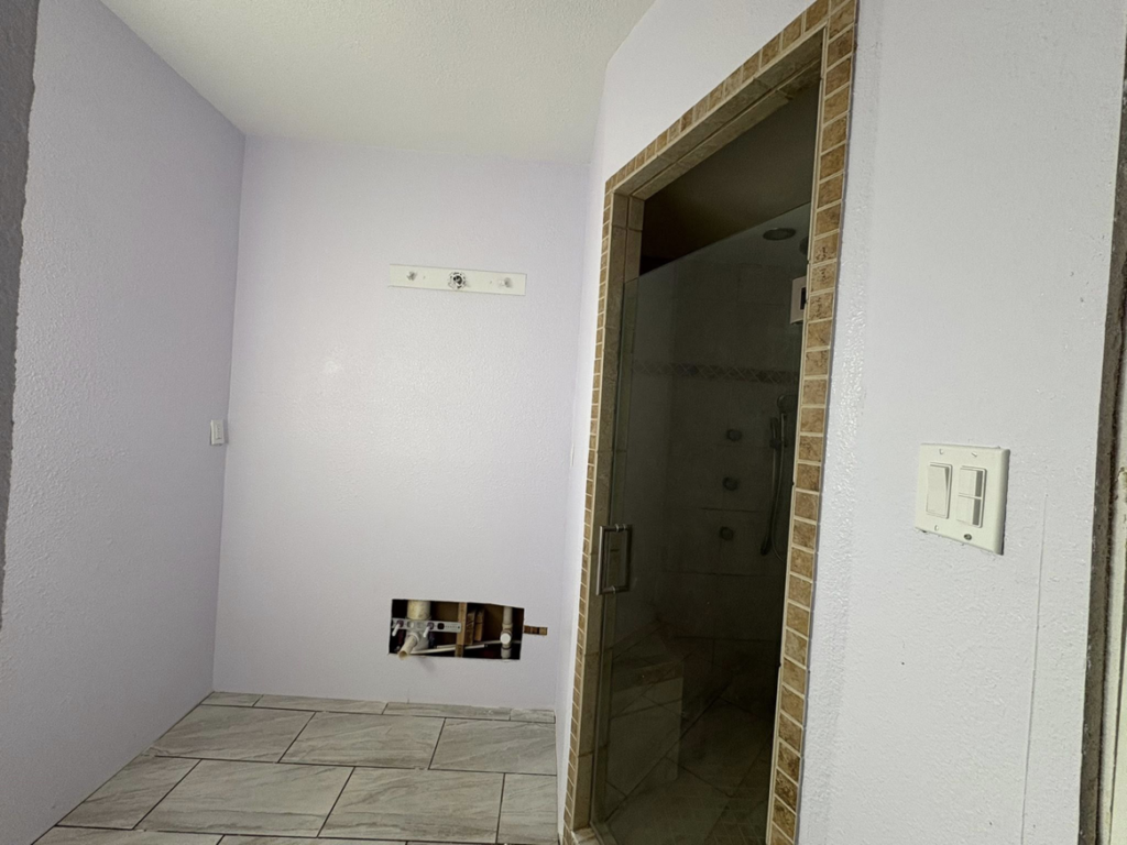A bathroom remodel in progress showing new floor tiling and plumbing rough-in by EJL Construction, LLC in Roswell, NM.