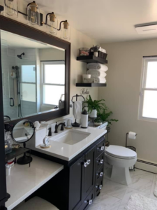 A renovated bathroom featuring a new vanity, toilet, and floating shelves by Solis and Son Construction in Denver, CO.