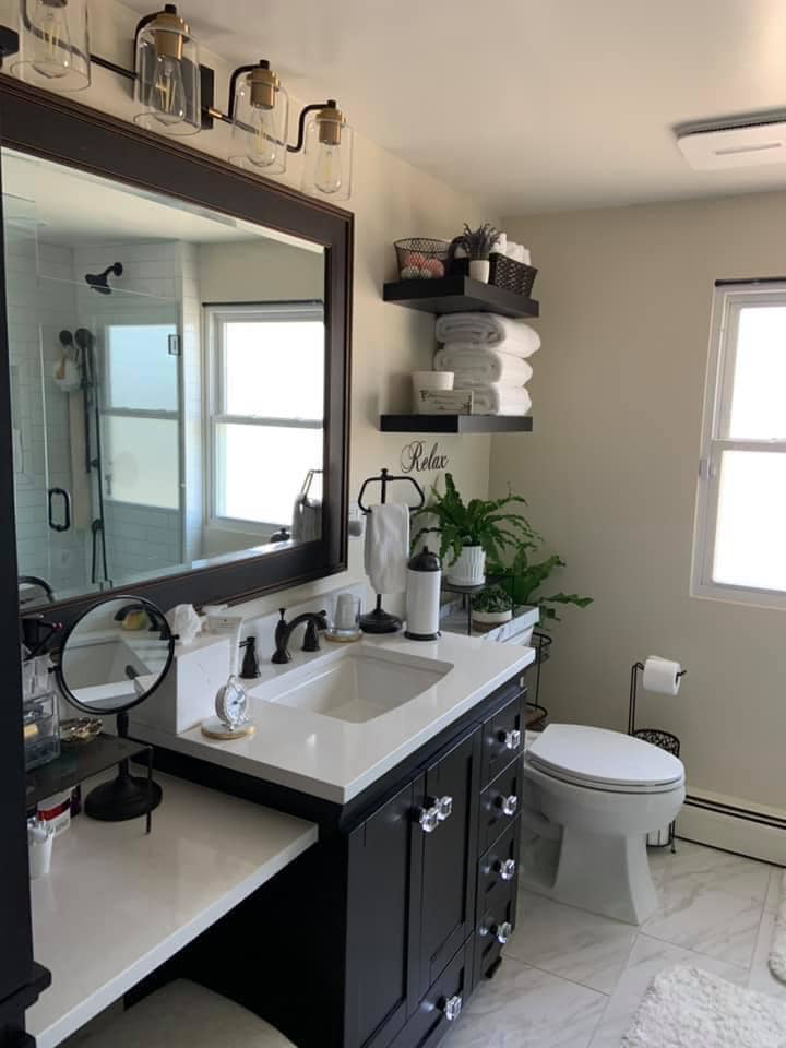 A renovated bathroom featuring a new vanity, toilet, and floating shelves by Solis and Son Construction in Denver, CO.