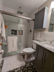 A beautifully remodeled bathroom with a walk-in shower and rain shower head by Better Than Your Last Handyman in St. Charles, MO.
