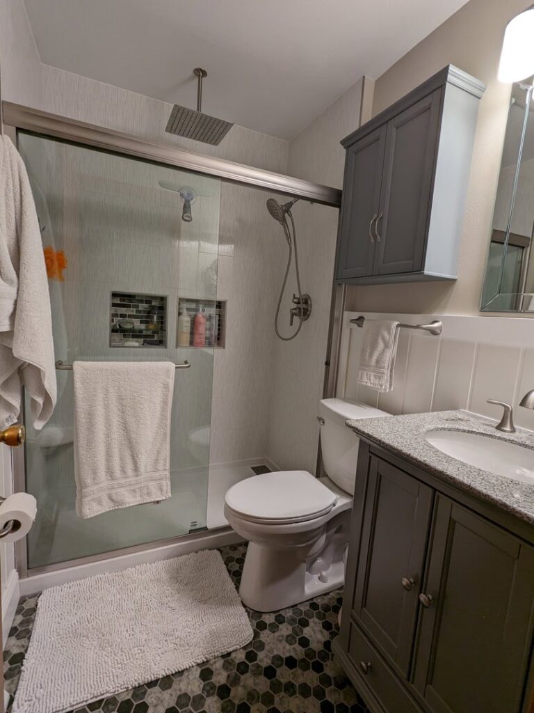 A beautifully remodeled bathroom with a walk-in shower and rain shower head by Better Than Your Last Handyman in St. Charles, MO.