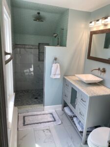 Completed bathroom remodel featuring a walk-in tiled shower and new vanity by CWS Handyman LLC in Seekonk, MA