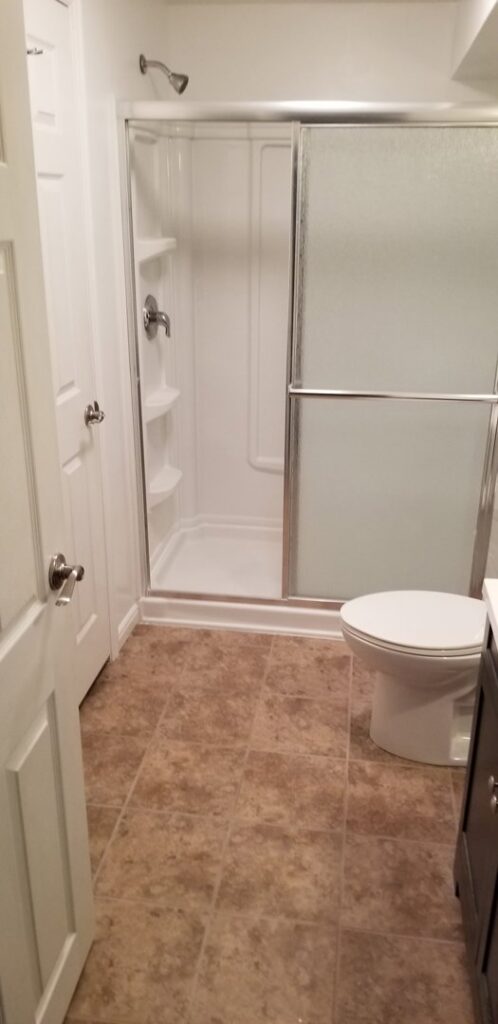 A completed bathroom remodel featuring a new shower enclosure, toilet, and tiled floor by Branham Handyman in Salt Lake City, UT