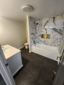 A completed bathroom renovation featuring a new bathtub, marble-look tile, and vanity by Joe's Handyman Solutions in Ogden, UT.