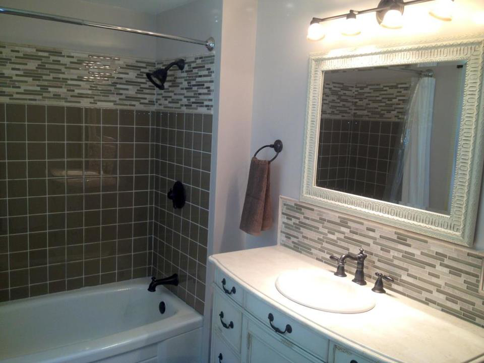 Bathroom renovation featuring a new bathtub, tiled walls, and vanity by Do It All Contracting in Rochester, NY.