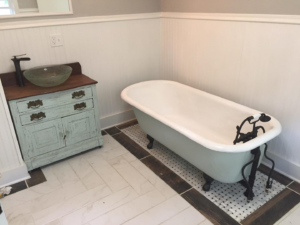 A newly renovated bathroom featuring a clawfoot tub and custom vanity by Executive Property Construction at 301 Maple Blvd.