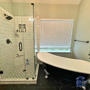 A renovated bathroom featuring a stylish clawfoot tub and a modern tiled shower with glass enclosure, by Roaring Lion Renovations, LLC in Houston, TX.