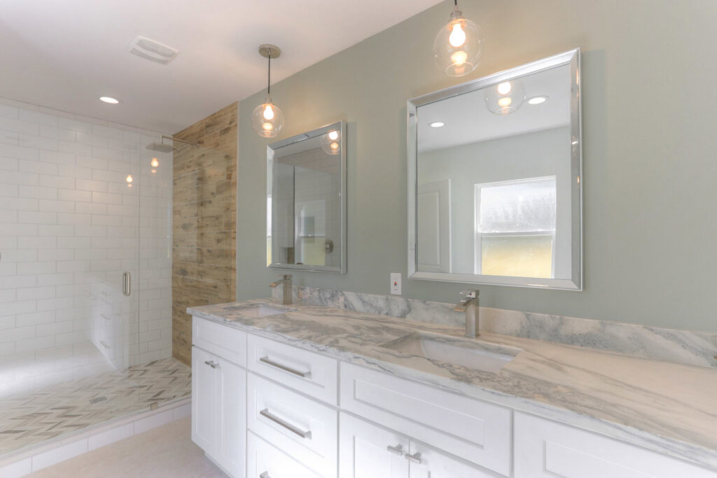 A newly renovated bathroom featuring a double vanity and a spacious walk-in shower by Pioneer Built in St. Petersburg, FL.