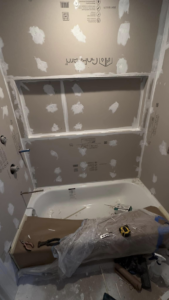 A bathroom renovation in progress with new drywall and bathtub installation by A Plus Handyman Service, LLC in Richland, MS.