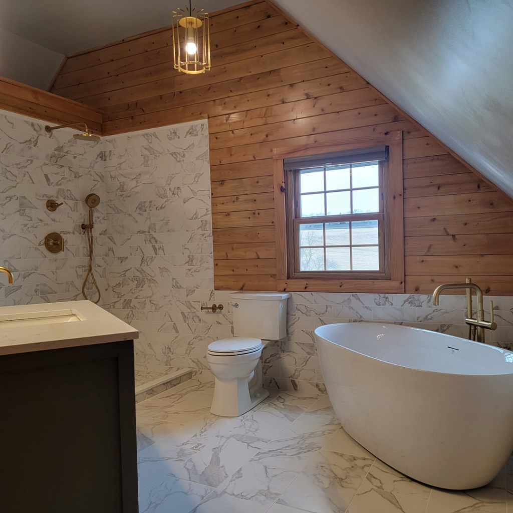 A beautifully renovated bathroom featuring a freestanding tub, tiled shower, and wood paneling by Jonny Hinton - Handyman Extraordinaire in Colorado Springs, CO.