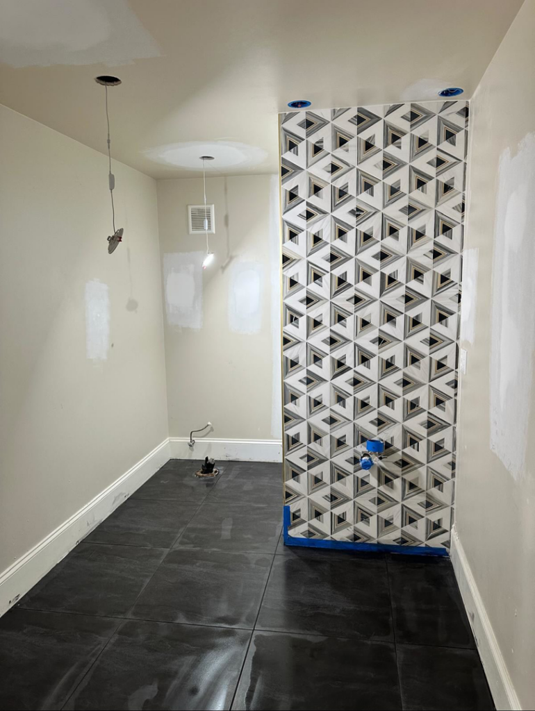 A bathroom renovation in progress showing geometric tile installation and new floor tiles by Home Renovation & Design in Trumbull, CT.