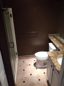 A newly renovated bathroom featuring a glass shower enclosure and granite vanity at Kingdom Advance Construction in Louisville, KY