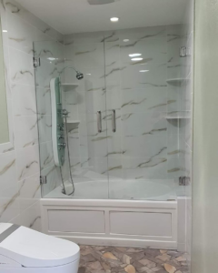 A beautifully renovated bathroom featuring a tiled shower and glass enclosure by Total Improvements LLC in San Antonio, TX.