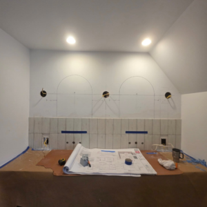 A bathroom renovation in progress with tiling and blueprints, showcasing Ember Works' general contractor services in Rochester, NY.