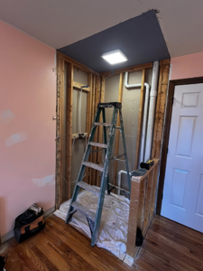 A bathroom renovation in progress showing exposed studs and plumbing by Fine Line Painting and Design in Georgetown, KY.