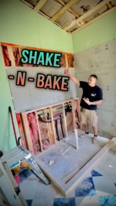 A general contractor inspecting a bathroom renovation in progress, showing framing and drywall by TEXAN Home Improvements LLC in San Antonio, TX.