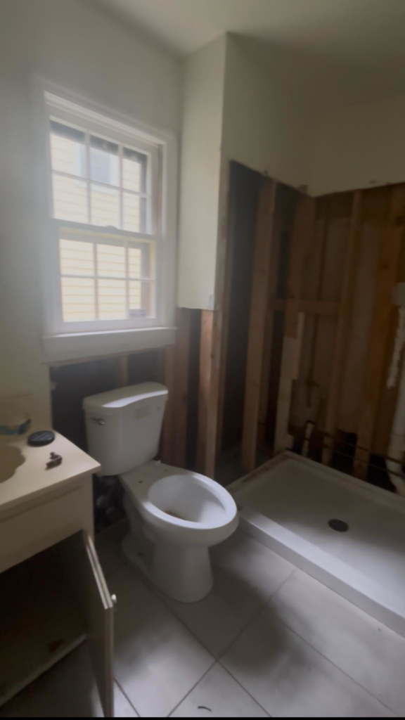 A bathroom undergoing renovation with exposed wall studs and a new shower pan installed by JJConstruction203 LLC in Charlotte, NC.