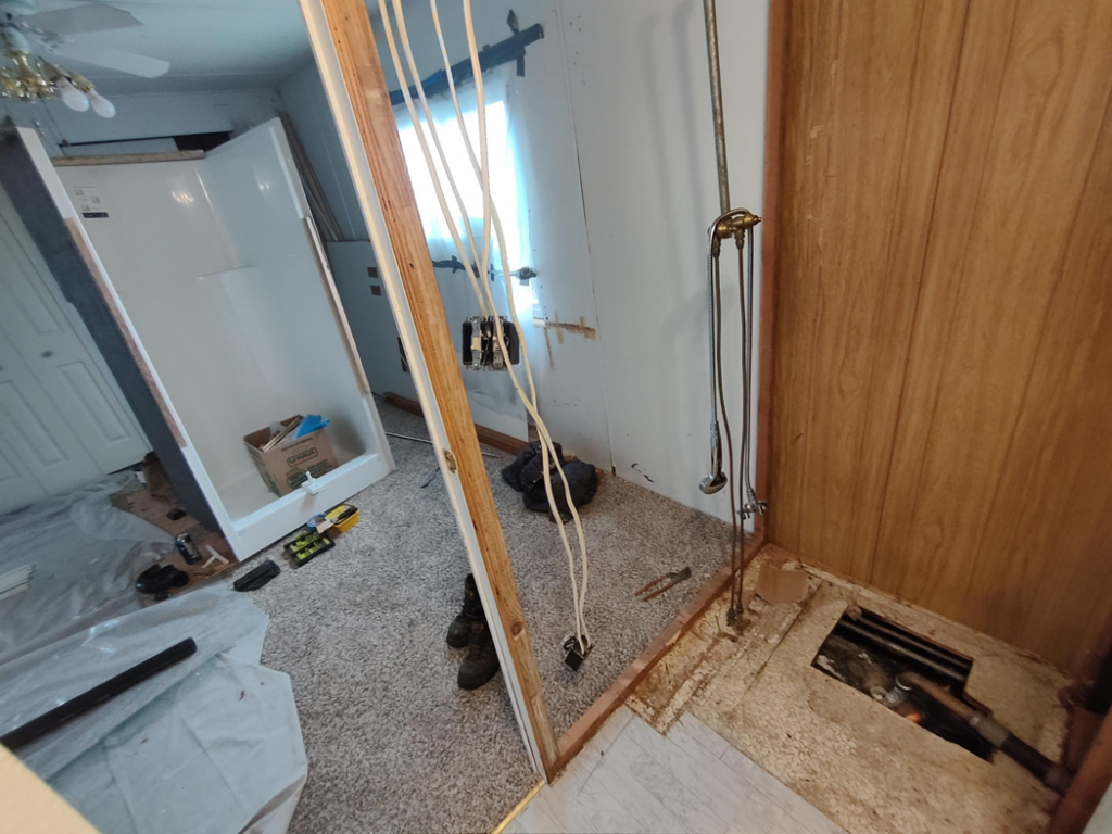 A bathroom undergoing renovation with new shower installation and exposed plumbing by JJU Property Maintenance, LLC in Salem, OR.