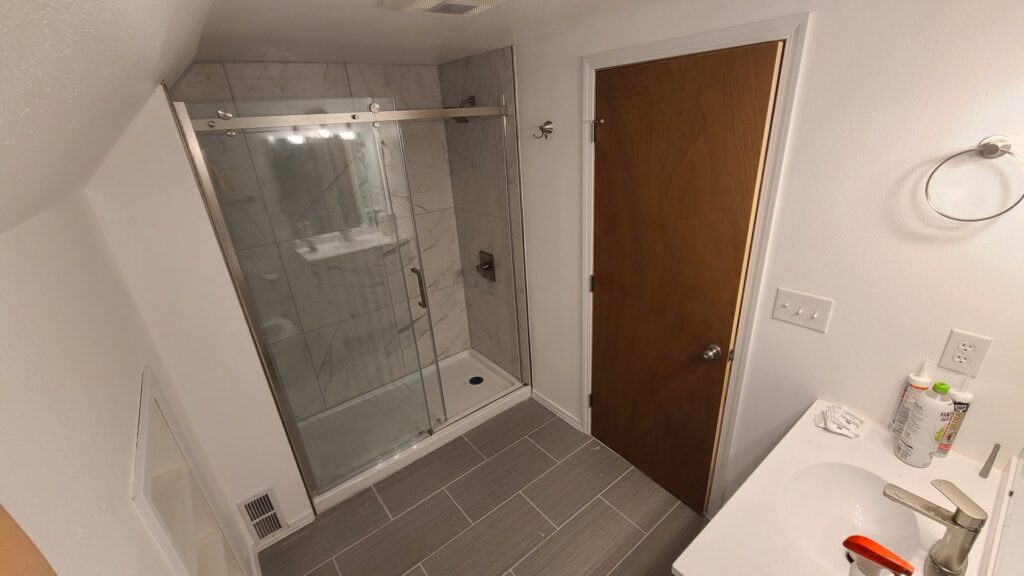 A newly renovated bathroom featuring a modern shower and vanity installed by Infinity Handyman in Anchorage, AK