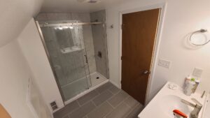 A newly renovated bathroom featuring a modern shower and vanity installed by Infinity Handyman in Anchorage, AK