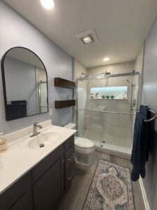 A stylish bathroom renovation featuring a single vanity, walk-in shower, and decorative mirror by Lynden Remodeling in Cincinnati, OH